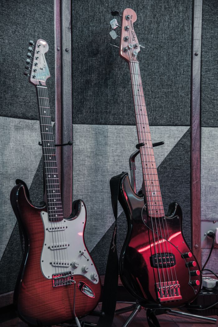 Services Two electric and bass guitars in a soundproof music studio setting. Perfect for music themes.