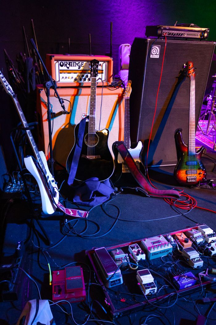 Services A vibrant collection of electric guitars, amplifiers, and pedals ready for a band performance.